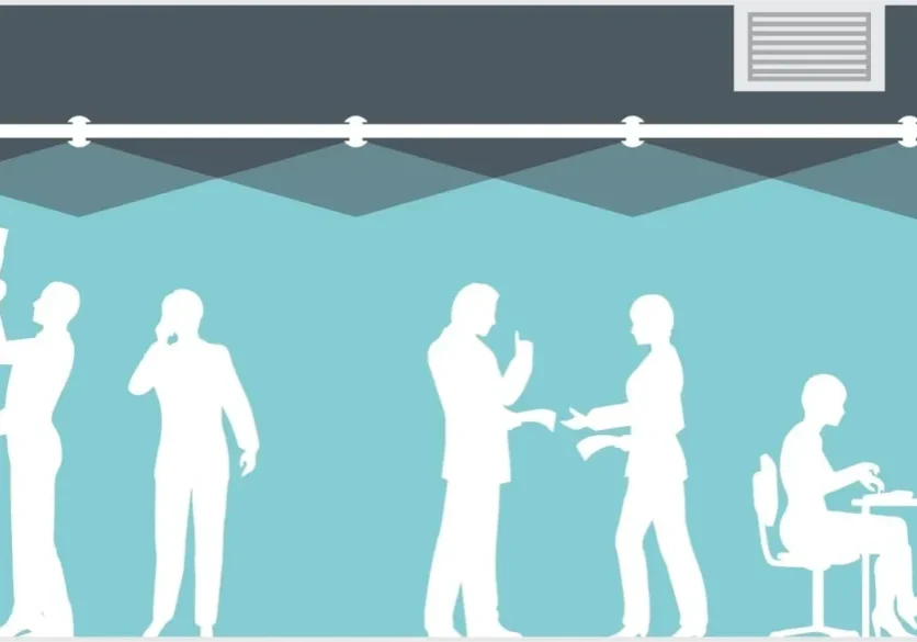 Silhouettes of businesspeople networking and shaking hands under spotlights.